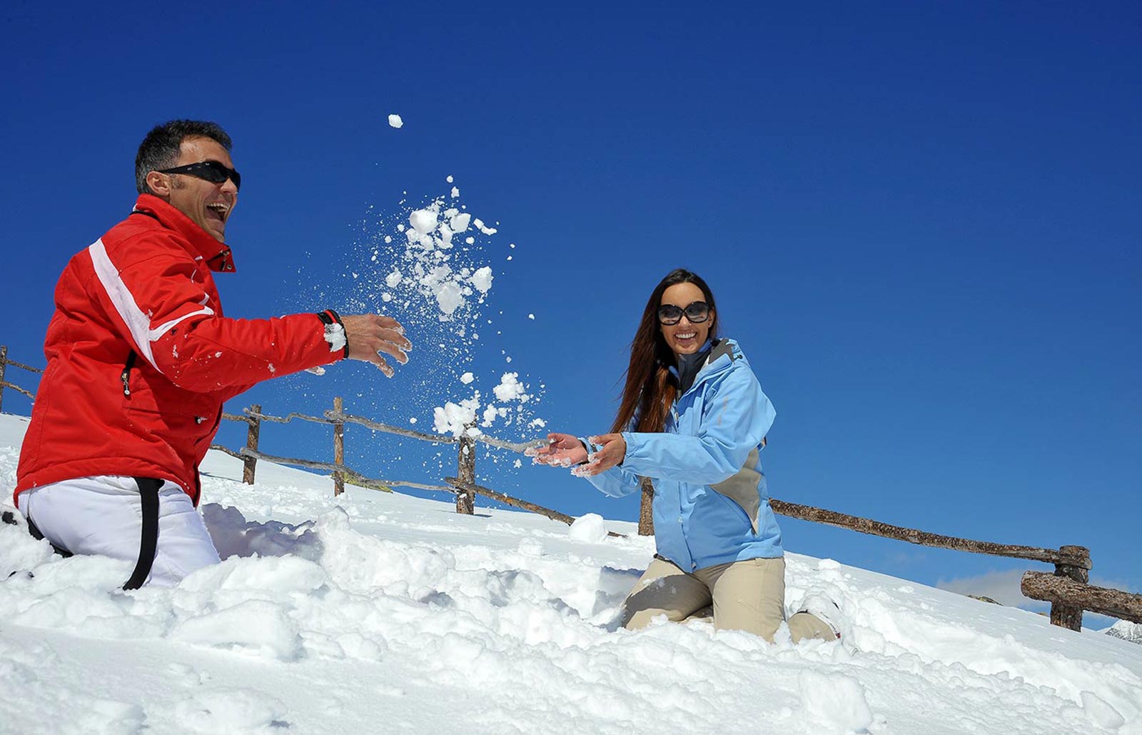 A couple is playing with snow in the South Tyrolean Dolomites