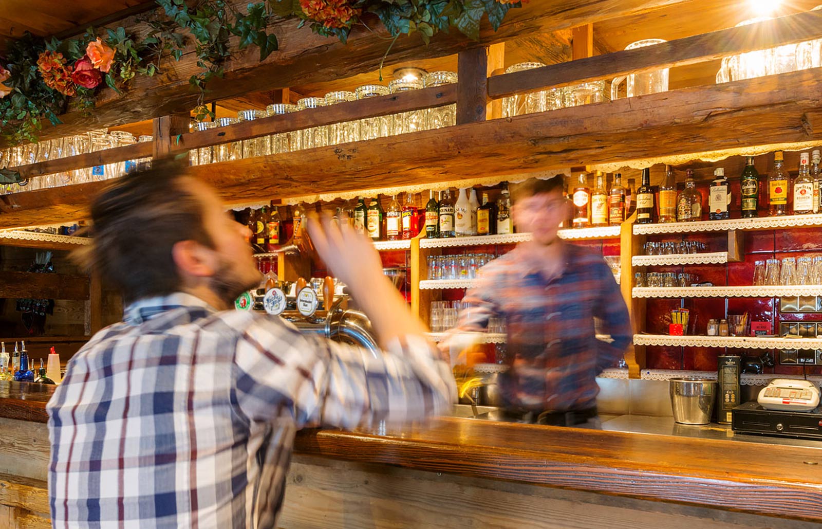 Ein Mann sitzt an der Theke im Rinschba Pub, dem Hauseigenen Disco Pub des Rinsbacherhof im urigen Stadl-Ambiente