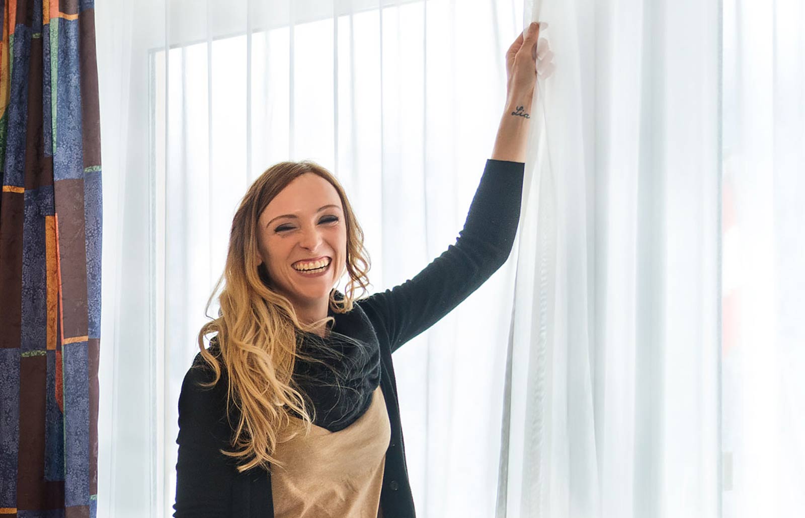 A young women closes the curtains in her hotel room at Rinsbacherhof