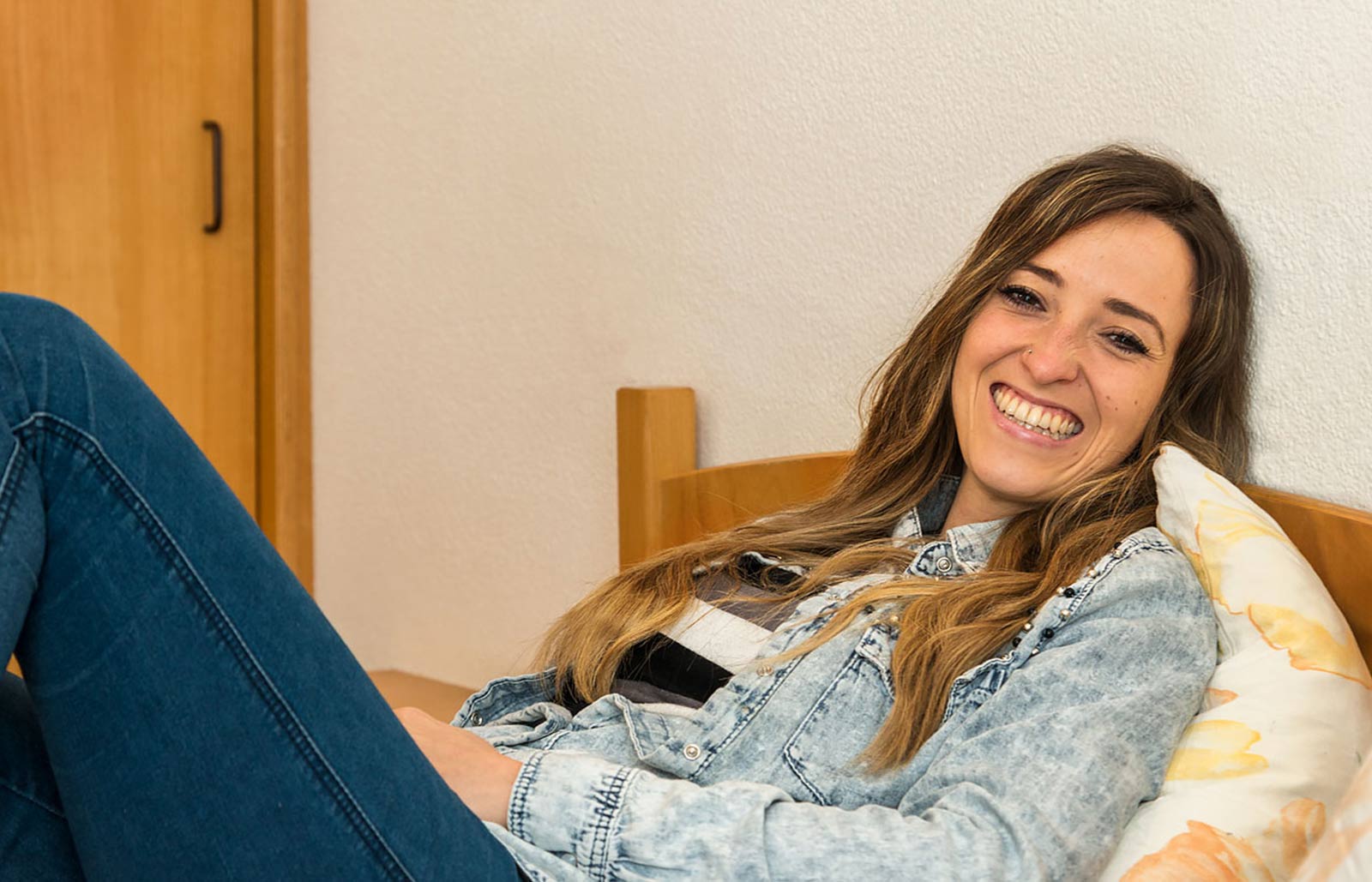 A young woman is resting on the bed in her hotel room